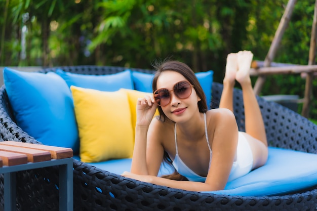 Retrato bela jovem asiática sorriso feliz relaxar ao redor da piscina