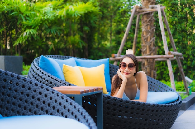 Retrato bela jovem asiática sorriso feliz relaxar ao redor da piscina