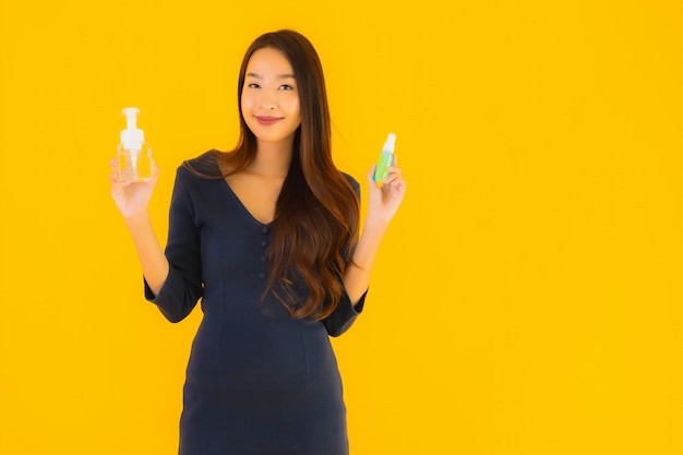 Retrato bela jovem mulher asiática com álcool gel e spray