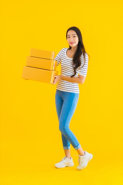 Retrato bela jovem mulher asiática com caixa de encomendas pronta para envio