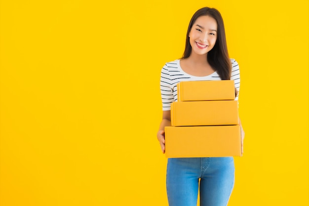 Retrato bela jovem mulher asiática com caixa de encomendas pronta para envio
