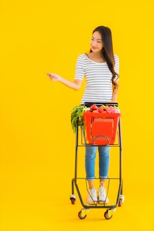 Retrato bela jovem mulher asiática com carrinho de supermercado cesta de supermercado em shopping