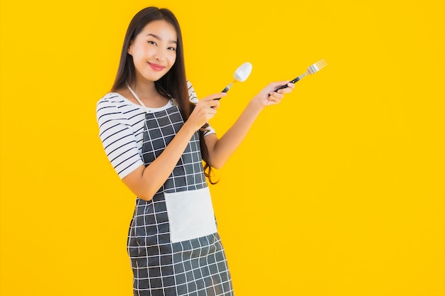 Retrato bela jovem mulher asiática com colher e garfo