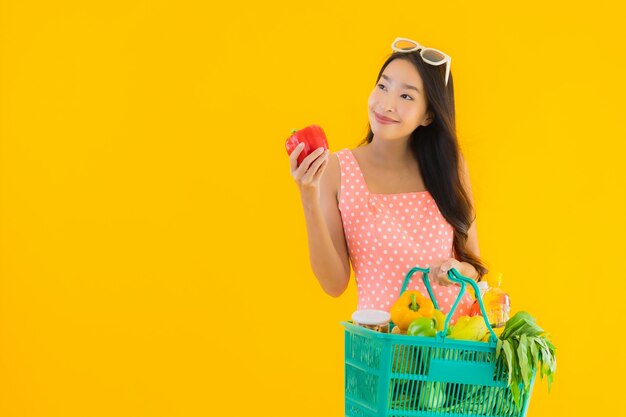 Retrato bela jovem mulher asiática com compras na cesta de compras de supermercado