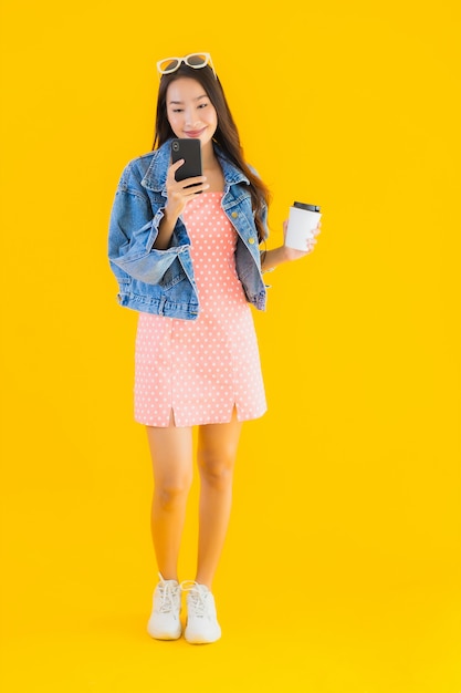 Retrato bela jovem mulher asiática com xícara de café e smartphone