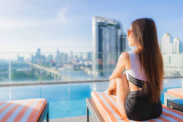 Retrato bela jovem mulher asiática relaxa lazer ao redor da piscina