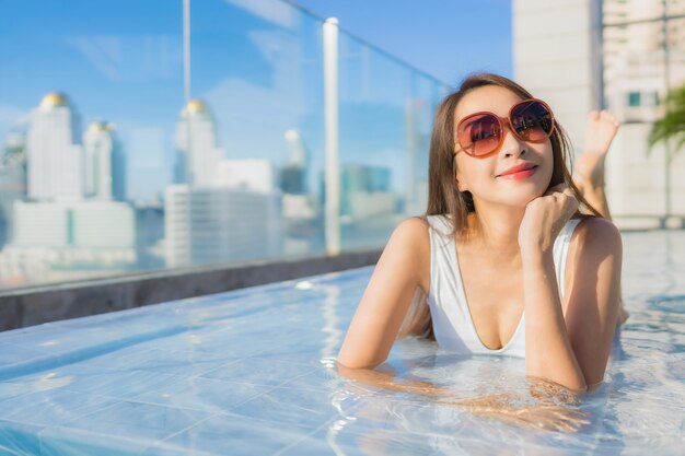 Retrato bela jovem mulher asiática relaxa lazer ao redor da piscina