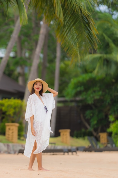 Retrato bela jovem mulher asiática sorriso feliz relaxar na praia mar oceano