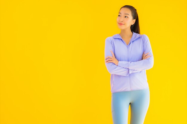 Retrato bela mulher asiática jovem esporte pronto para exercício amarelo