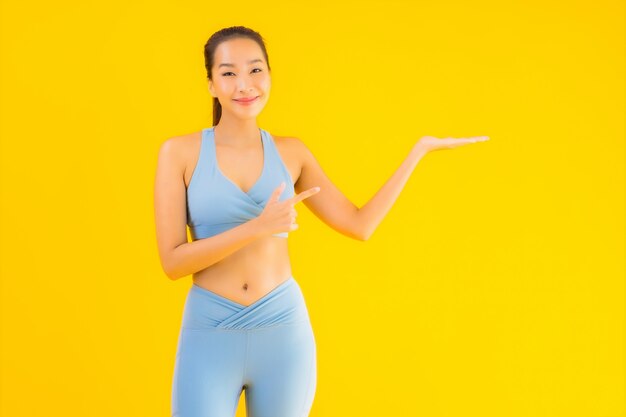 Retrato bela mulher asiática jovem esporte pronto para exercício amarelo