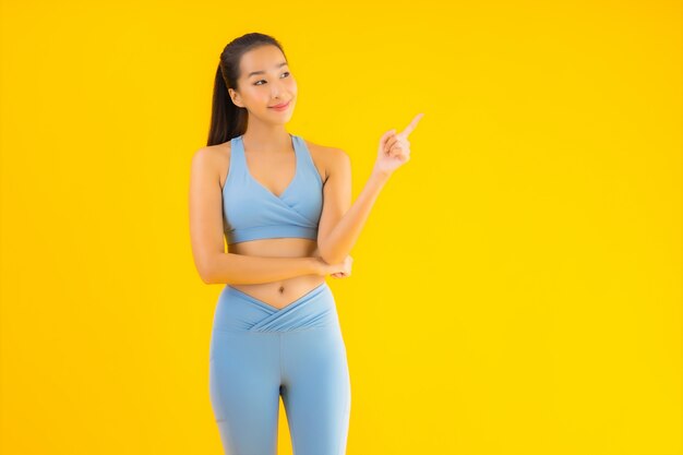 Retrato bela mulher asiática jovem esporte pronto para exercício amarelo