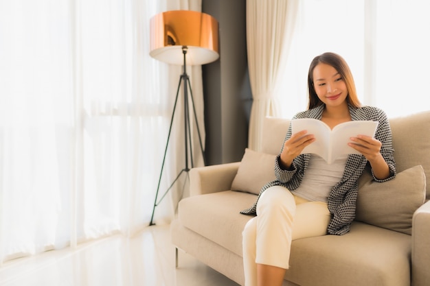 Foto grátis retrato belas jovens mulheres asiáticas lendo livro e sentado na cadeira do sofá