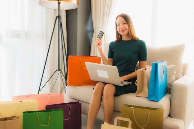 Retrato belas jovens mulheres asiáticas usando computador laptop com cartão de crédito para compras on-line