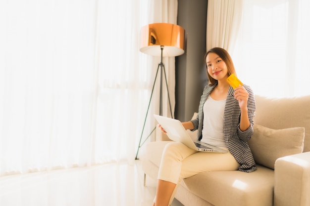 Retrato belas jovens mulheres asiáticas usando computador portátil ou telefone móvel e inteligente com cartão de crédito para compras on-line