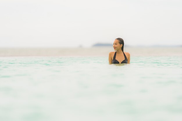 Retrato, bonito, jovem, mulher asian, desgaste, biquíni, ao redor, piscina, em, hotel, recurso, quase, mar oceano, praia