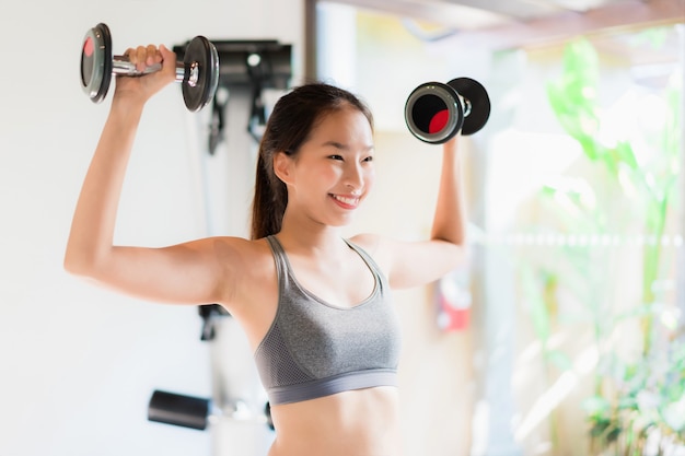 Retrato, bonito, jovem, mulher asian, exercício, com, equipamento aptidão, em, ginásio, interior