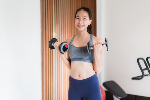 Retrato, bonito, jovem, mulher asian, exercício, com, equipamento aptidão, em, ginásio, interior