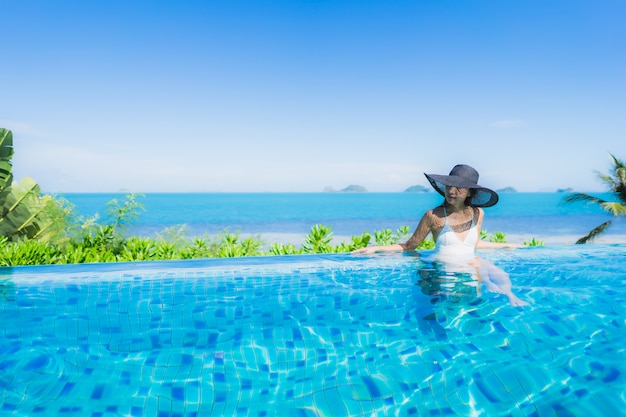 Foto grátis retrato, bonito, jovem, mulher asian, relaxe, em, luxo, piscina ao ar livre, em, hotel, recurso, quase, praia, mar, oceânicos