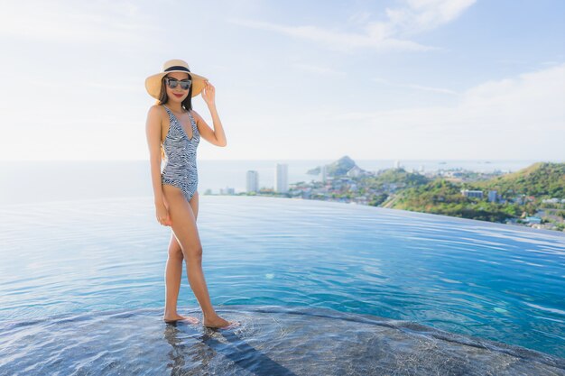 Retrato, bonito, jovem, mulher asian, sorrizo, feliz, relaxe, ao redor, piscina, em, hotel, recurso, para, lazer