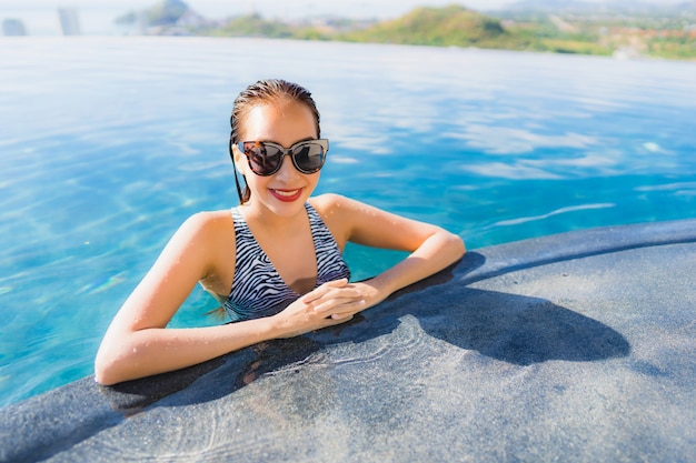 Retrato, bonito, jovem, mulher asian, sorrizo, feliz, relaxe, ao redor, piscina, em, hotel, recurso, para, lazer