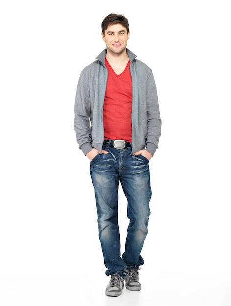 Retrato completo de homem bonito feliz sorridente na jaqueta cinza, jeans azul. Cara bonito isolado no branco