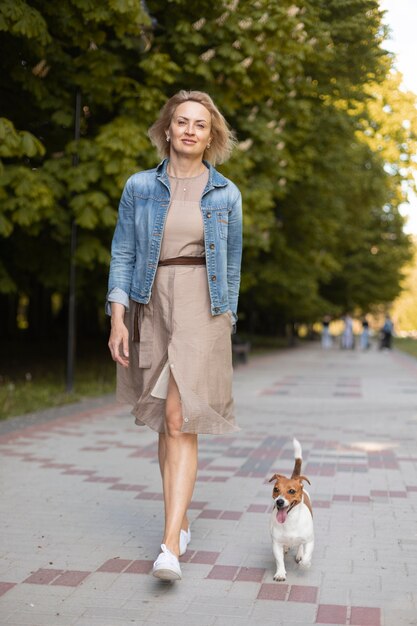 Retrato completo de mulher caminhando com cachorro