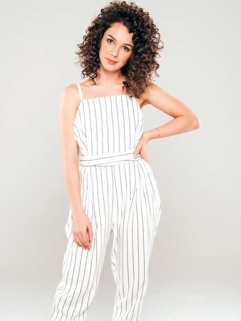 Foto grátis retrato da bela modelo sorridente com penteado de cachos afro, vestido com roupas de hipster de verão. garota despreocupada sexy, posando no estúdio em fundo cinza. mulher na moda engraçada e positiva