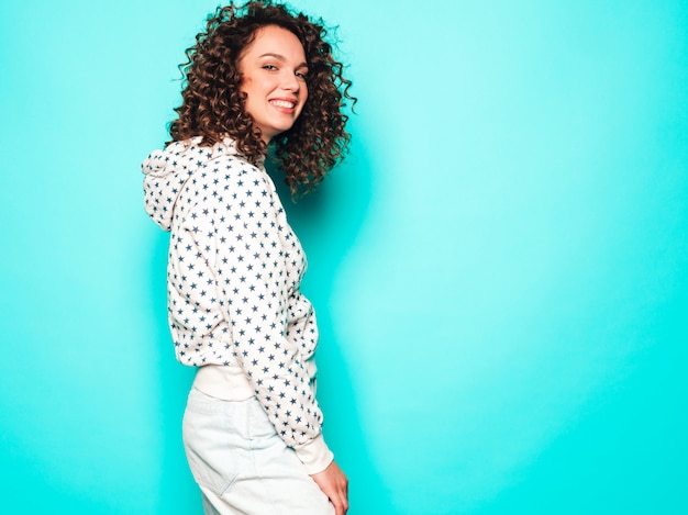 Retrato da bela modelo sorridente com penteado de cachos afro, vestido com roupas de hipster de verão. Mulher na moda engraçada e positiva com capuz branco