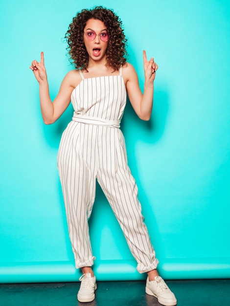 Retrato da bela modelo sorridente com penteado de cachos afro, vestido com roupas de hipster de verão. na moda, mulher engraçada e positiva