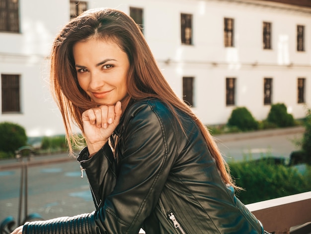 Foto grátis retrato da bela modelo sorridente. mulher vestida com calça jeans e jaqueta de couro preto hipster de verão. mulher na moda posando na rua