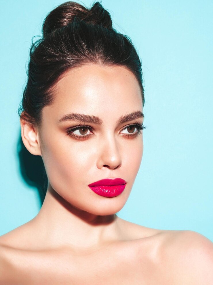 Foto grátis retrato da beleza da moda da jovem morena com maquiagem elegante à noite e pele limpa perfeita modelo sexy com cabelo em um coque posando no estúdio com lábios naturais brilhantes rosa