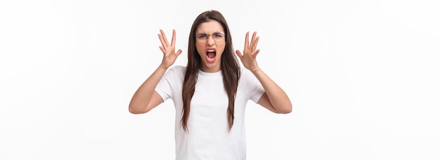 Foto grátis retrato da cintura para cima de uma linda garota morena irritada em óculos gritando culpando o parceiro por che