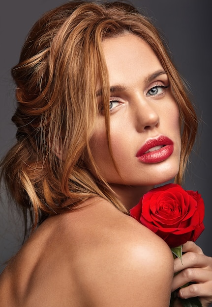 Retrato da moda beleza de modelo jovem loira com maquiagem natural e pele perfeita com linda rosa posando
