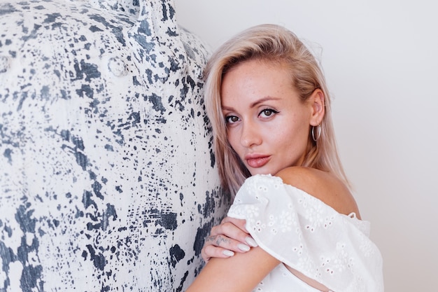 Retrato da moda de jovem europeu com cabelo loiro em um vestido branco de verão longo