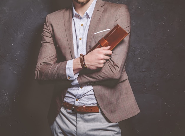 Foto grátis retrato da moda do homem bonito modelo jovem empresário vestido elegante terno marrom com acessórios