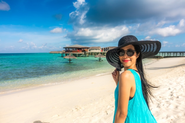 Foto grátis retrato da mulher nova feliz na casa de campo bonita da água na ilha de maldives. viagens e férias. tiro ao ar livre