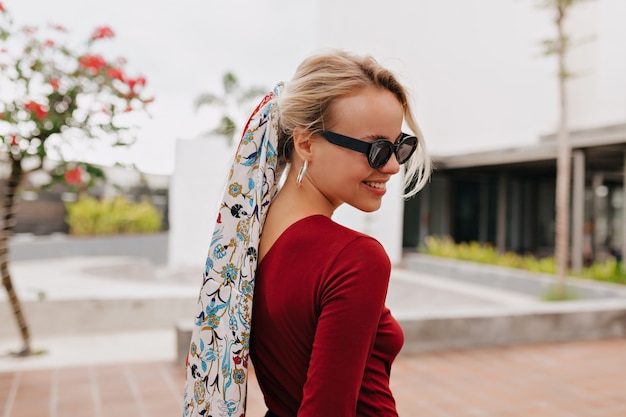 Retrato das costas de uma linda mulher usando um xale na cabeça e óculos de sol pretos