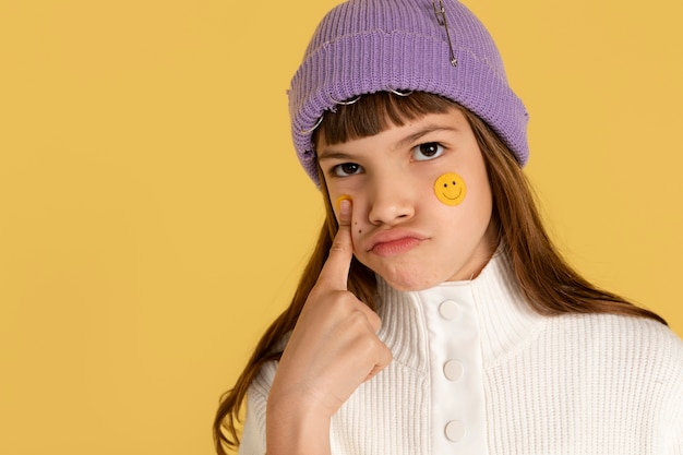 Retrato de adolescente apontando e vestindo um gorro