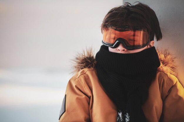 Foto grátis retrato de adolescente no cachecol e óculos de proteção de snowboard lá fora em dia de inverno brilhante.