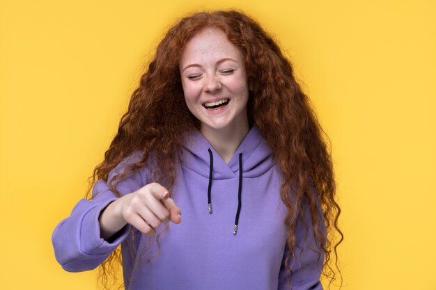 Retrato de adolescente rindo e apontando para algo