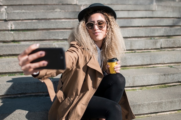 Retrato de adolescente urbano tomando uma selfie