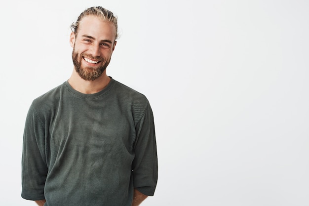 Retrato de alegre barbudo bonitão com penteado elegante sorrindo