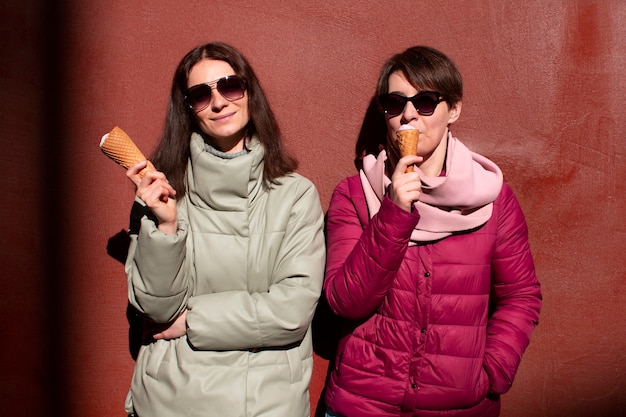 Foto grátis retrato de amigas ao ar livre com casquinhas de sorvete