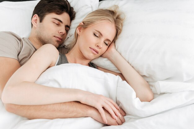 Retrato de casal bonito calmo, dormindo na cama