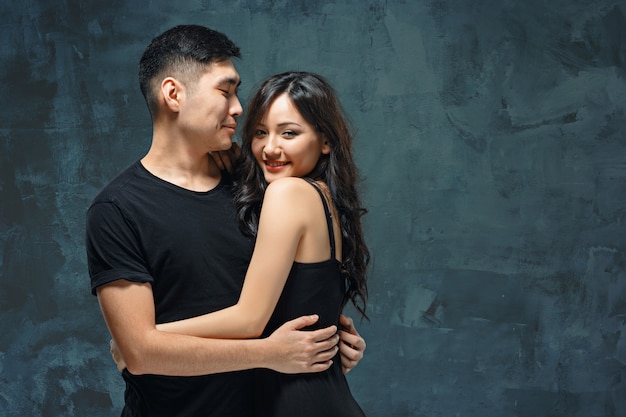 Retrato de casal coreano sorridente em um cinza