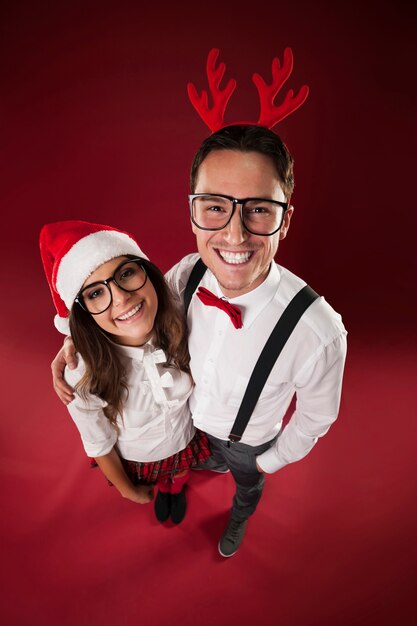 Retrato de casal nerd sorridente na época do natal