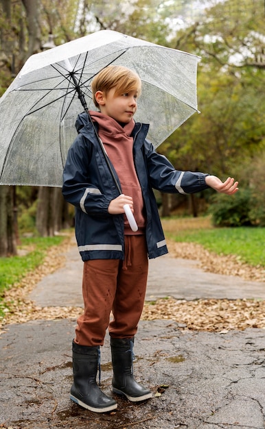 Retrato de chuva de um menino jovem e bonito