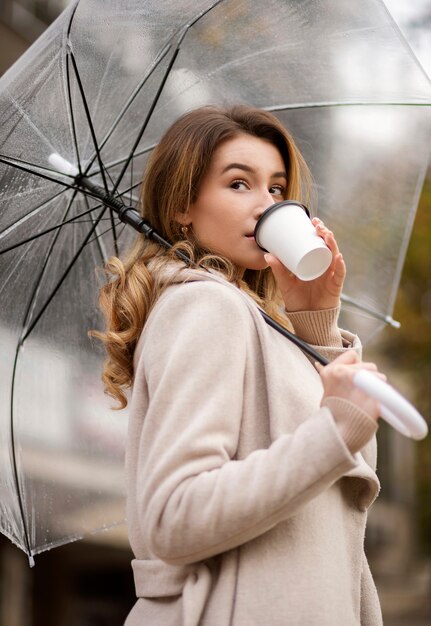 Retrato de chuva de uma jovem mulher bonita com guarda-chuva