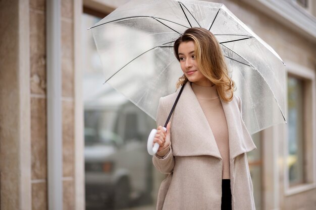 Retrato de chuva de uma jovem mulher bonita com guarda-chuva