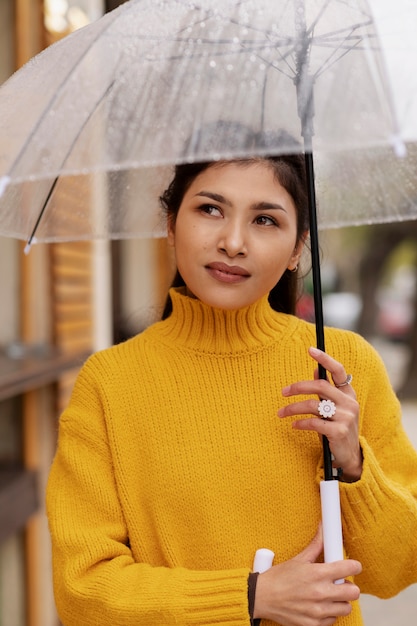 Foto grátis retrato de chuva de uma mulher jovem e bonita com guarda-chuva